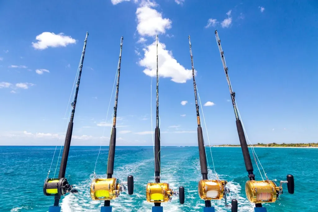 Cañas y carretes de pesca deportiva navegando frente a la costa del Pacífico de Costa Rica